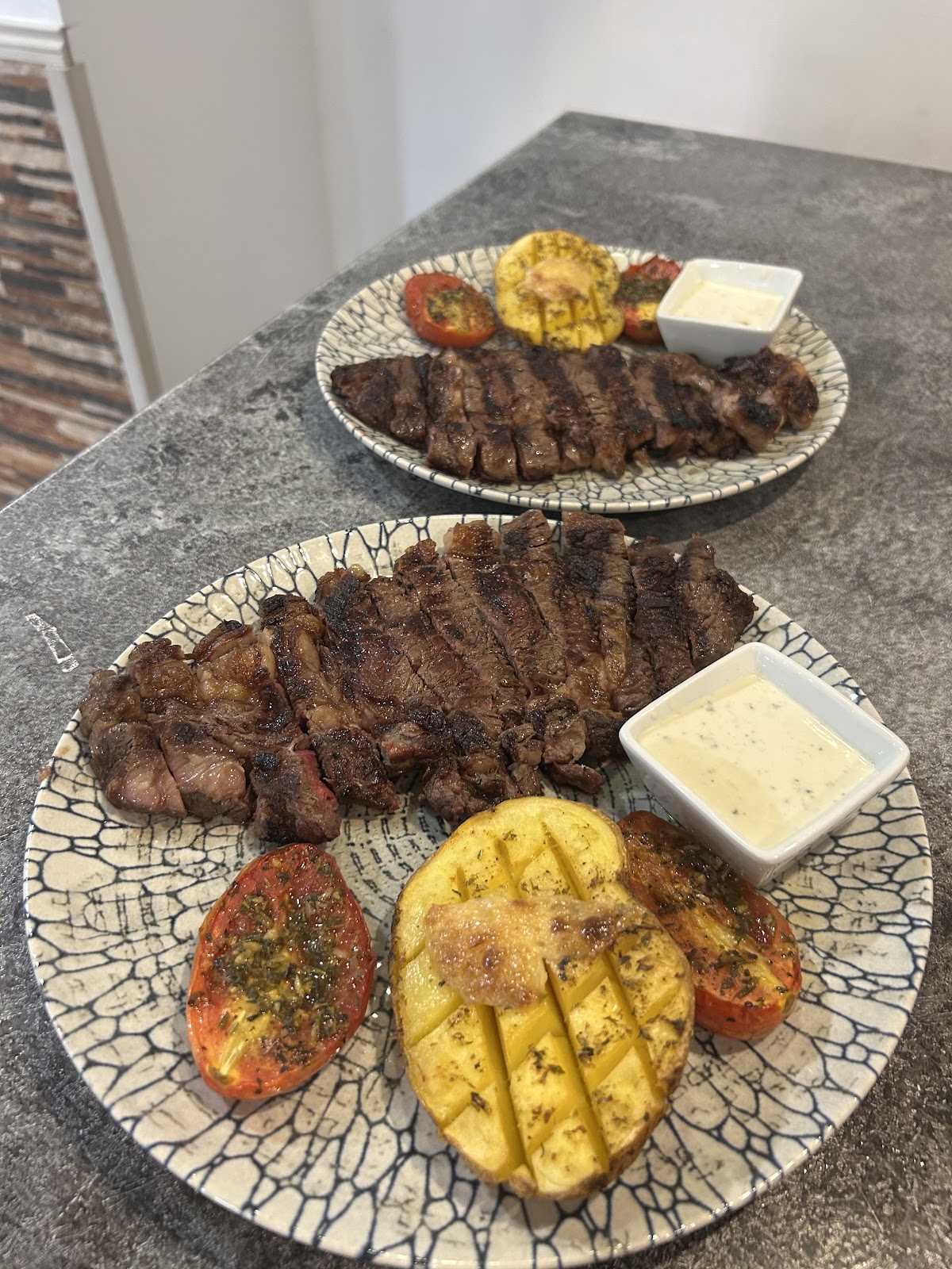 Dos plats de carn a la brasa amb verdures i salsa